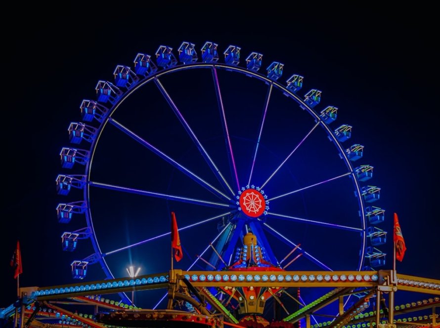 Großes beleuchtetes Riesenrad auf einem abendlichen Festplatz