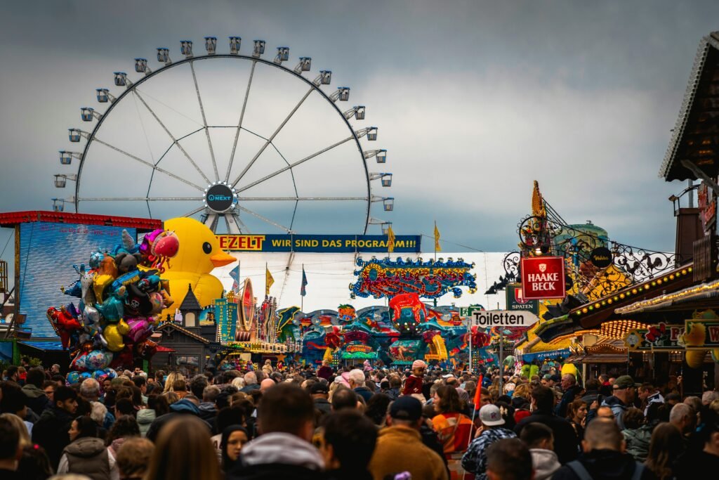 Bremer Freimarkt 1 Besucher auf dem Bremer Freimarkt vor dem Riesenrad und bunten Fahrgeschäften